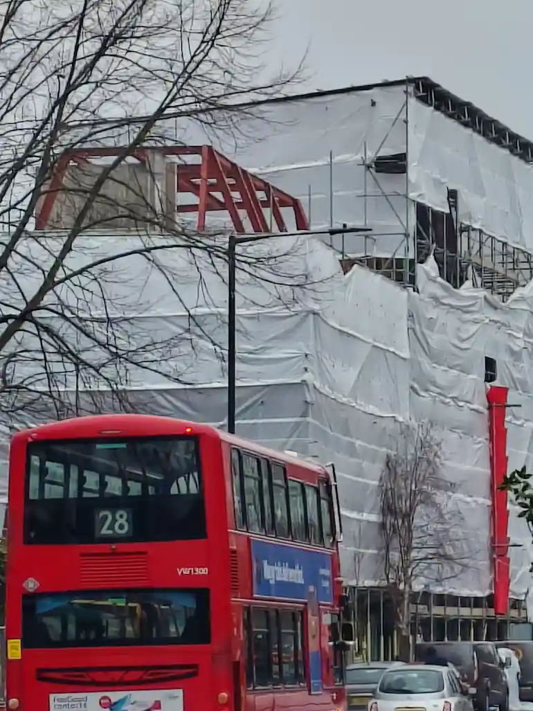 Photograph of a bus passing Harrow Road construction site